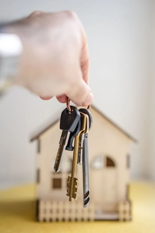 Holding keys infront of a small house Affordable Conveyancing